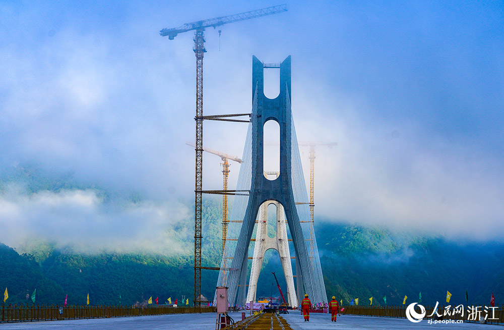 7月8日，兩名工人前往高嶺頭水庫特大橋項目現場。人民網 章勇濤攝