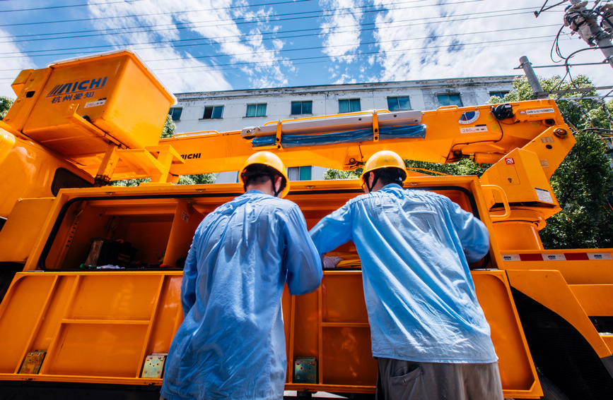 臺州黃巖區電力工作者身著厚厚的絕緣服，在40度的高溫“烤”驗下，連續奮戰2個多小時。馮靜攝