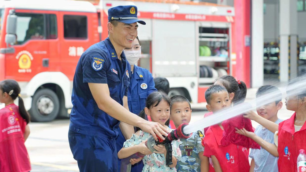 孩子們在指導下使用水槍開展了模擬滅火撲救演練。姚遙攝