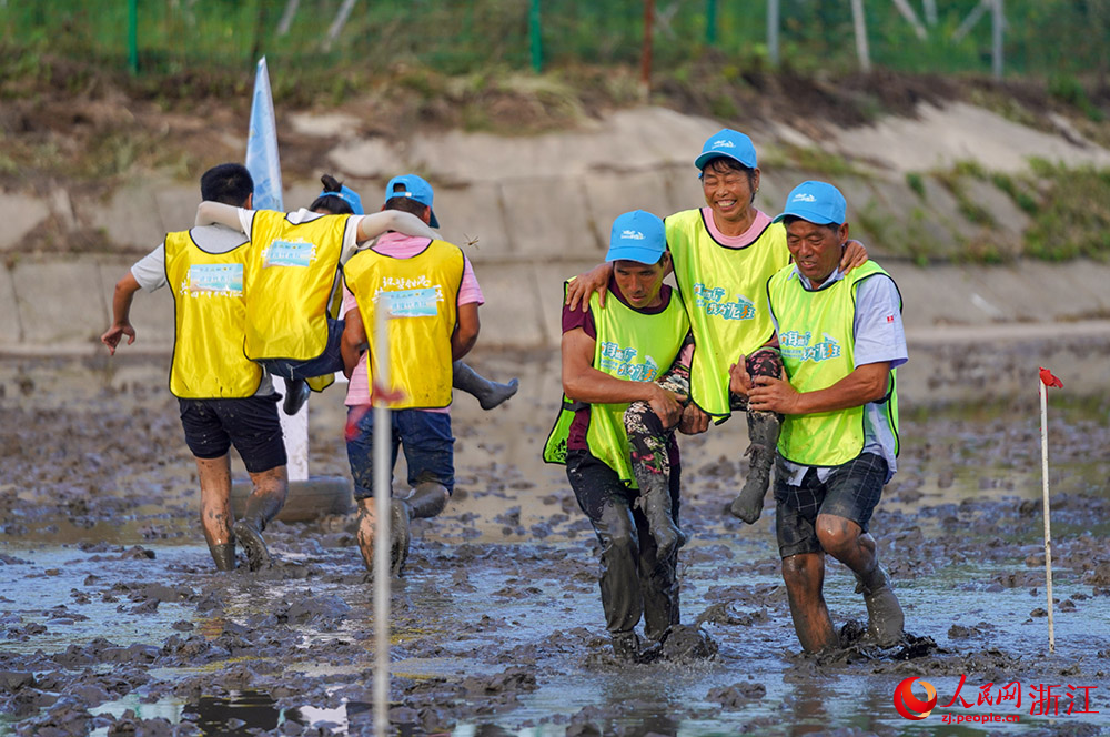 參賽選手在灘涂上進行灘涂救援項目的比賽。人民網 章勇濤攝