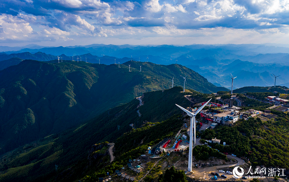 一臺臺發電機矗立在群山之中，蔚為壯觀，成為一道亮麗的風景線。人民網 章勇濤攝