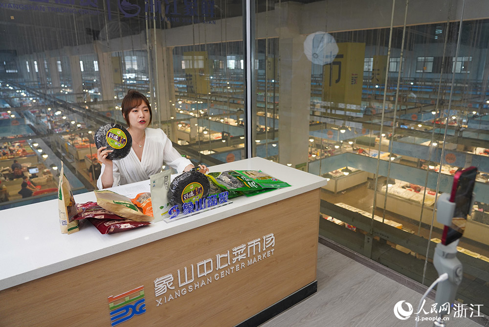 一主播在寧波市象山縣中心菜市場的“公共直播間”里直播帶貨。人民網 章勇濤攝