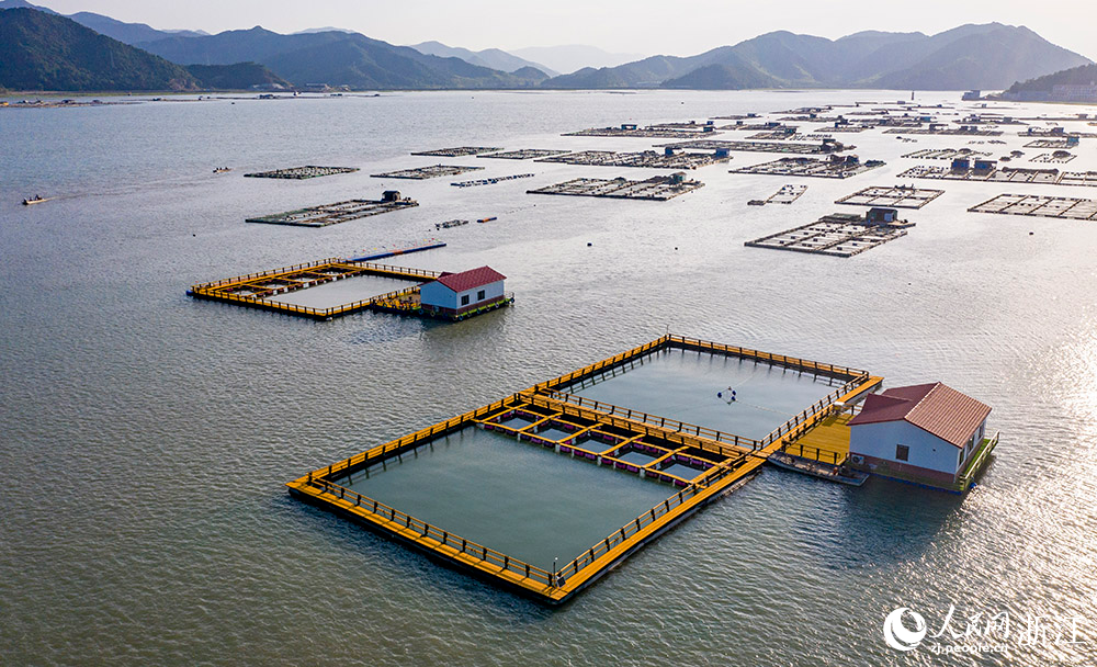 一方方橙黃色的養殖設施有序排列在蔚藍的海面上，成為斑斕海岸線一道亮麗的風景。人民網 章勇濤攝
