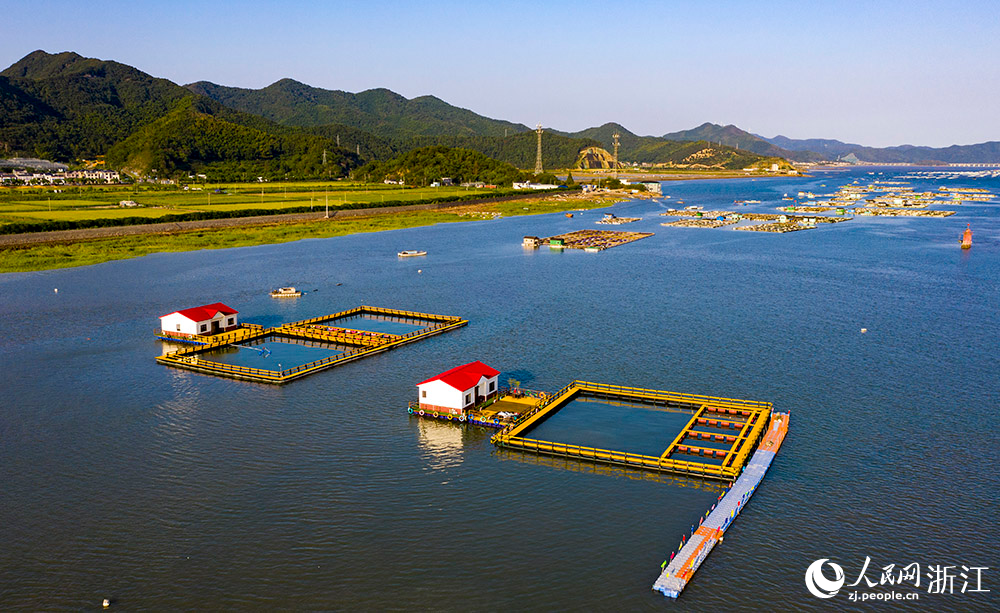 一方方橙黃色的養殖設施有序排列在蔚藍的海面上，成為斑斕海岸線一道亮麗的風景。人民網 章勇濤攝