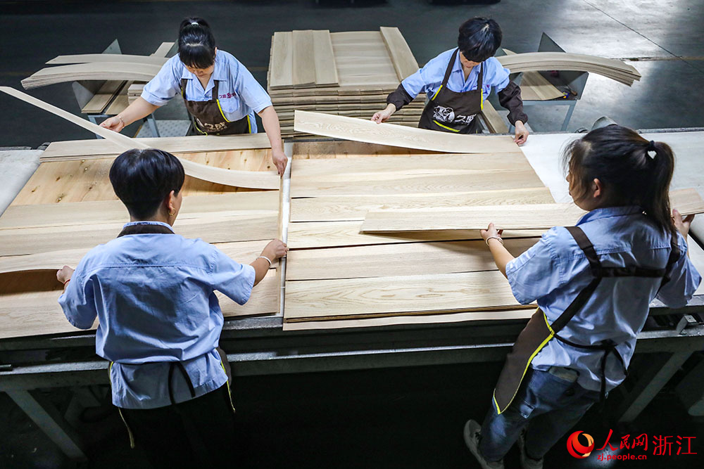 近日，在湖州市南潯區一地板企業，工作人員在對地板進行加工。人民網 章勇濤攝