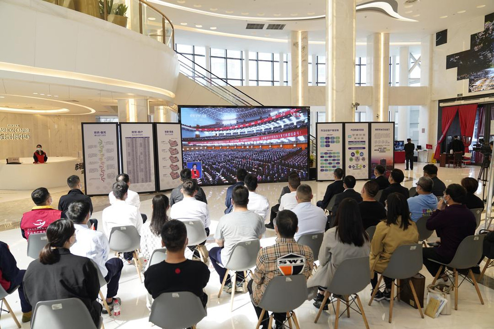 10月16日上午，在嘉興桐鄉濮院羊毛衫市場時尚中心一樓的大屏前，30多名黨員經營戶、新居民黨員和市場黨員干部認真觀看黨的二十大開幕會。陳建鐘攝