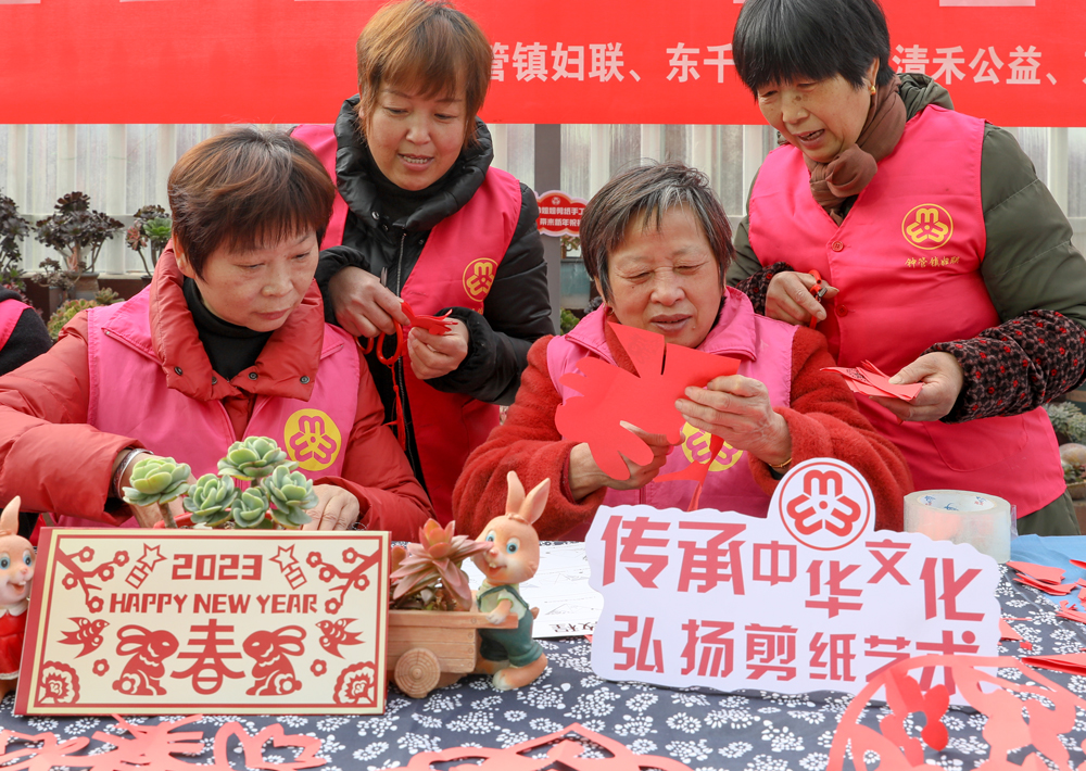 婦女將一張張紅紙剪成各種圖案。白羽攝