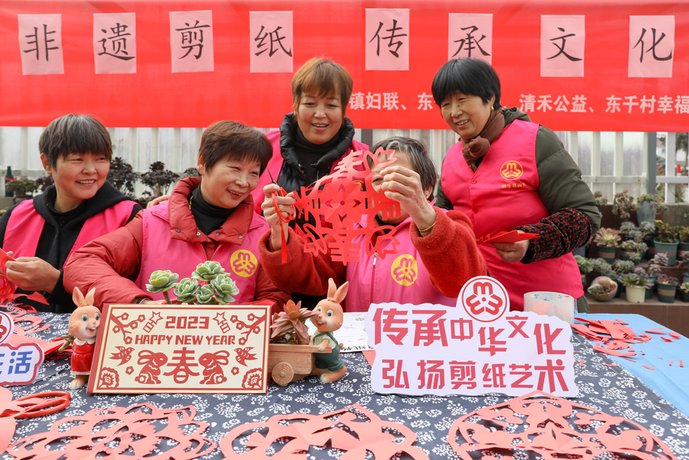 婦女將一張張紅紙剪成各種圖案。白羽攝