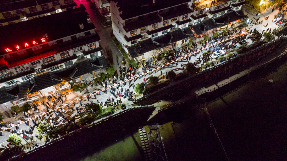 金竹溪村鑼鼓喧天，人頭攢動，村民舞起一條360多米長的“板凳龍”，吸引了周邊村民前來觀看。陳月明攝