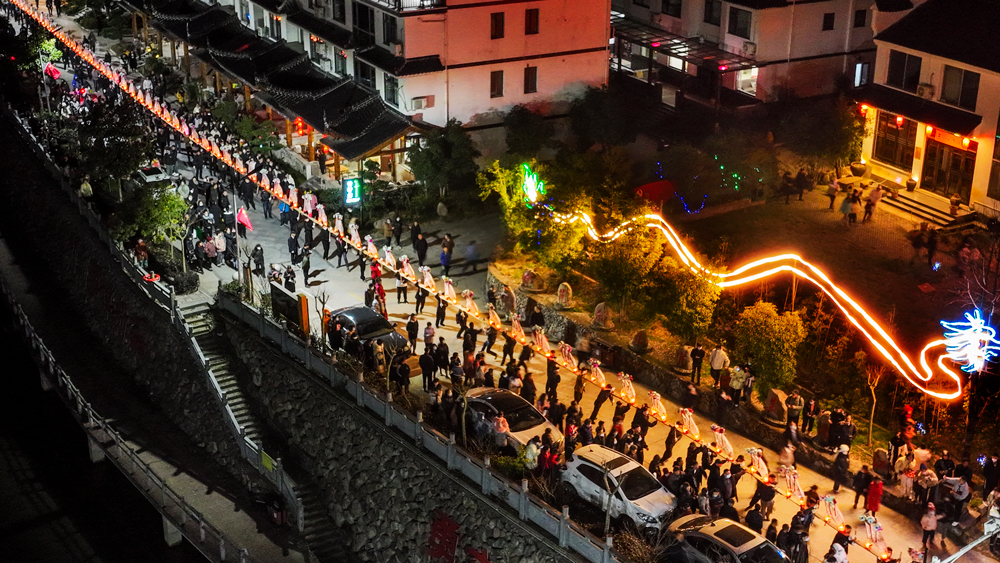 金竹溪村鑼鼓喧天，人頭攢動，村民舞起一條360多米長的“板凳龍”，吸引了周邊村民前來觀看。陳月明攝