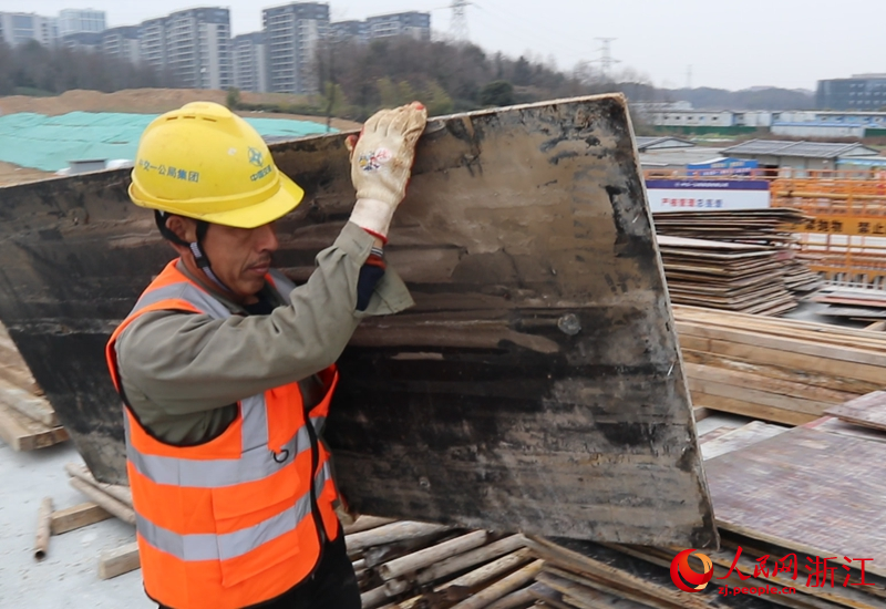 鄧勤倬搬運拆卸下的木板。人民網 張帆攝