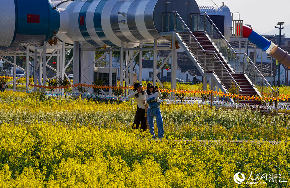 一列橙黃色的八節雙層火車“靜臥”在七彩油菜花海邊，吸引不少游客前來品咖啡、賞春色。人民網 章勇濤攝