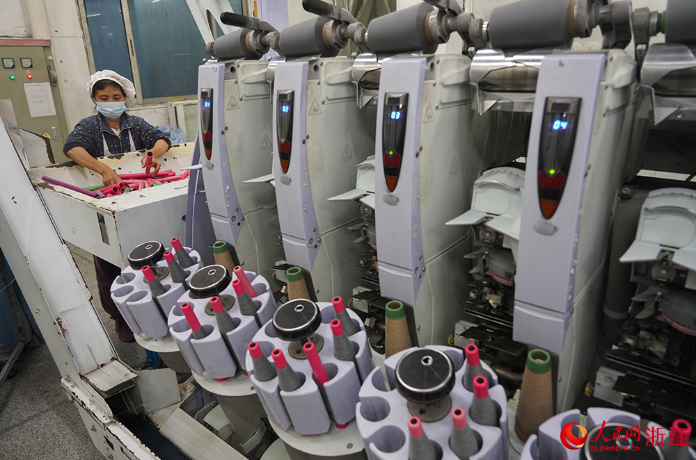 工人在車間紡織作業，一片忙碌。人民網 章勇濤攝