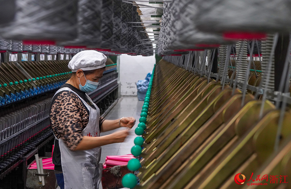工人在車間紡織作業，一片忙碌。人民網 章勇濤攝