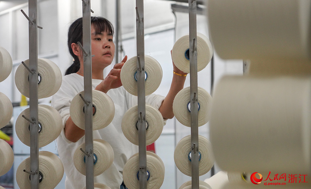 工人在車間紡織作業，一片忙碌。人民網 章勇濤攝