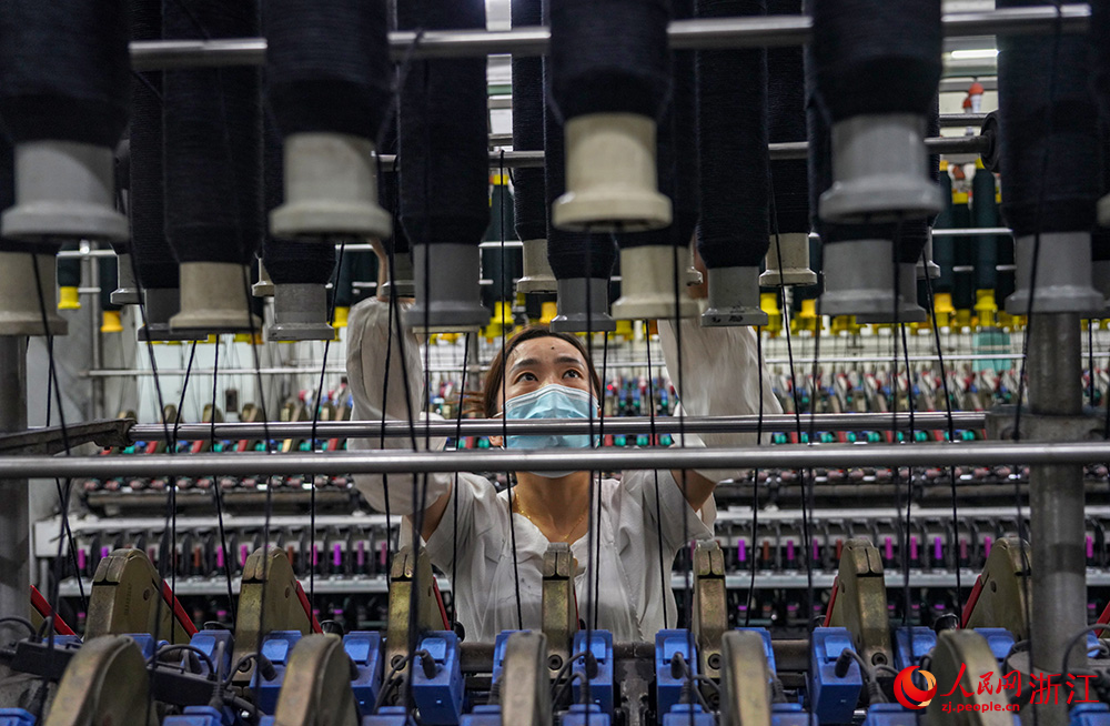 工人在車間紡織作業，一片忙碌。人民網 章勇濤攝