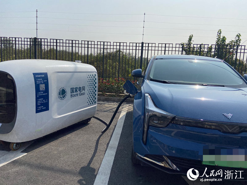 移動充電機器人正在為新能源汽車充電。人民網 方彭依夢攝