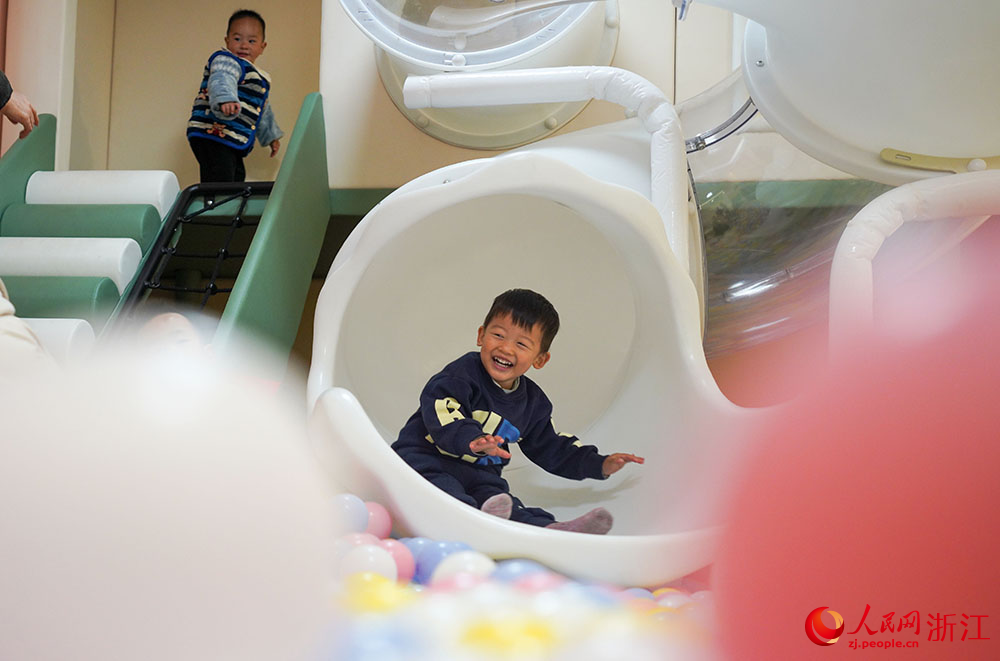 在寧波市鎮海區招寶山街道鄰里中心，小朋友在滑滑梯。人民網 章勇濤攝