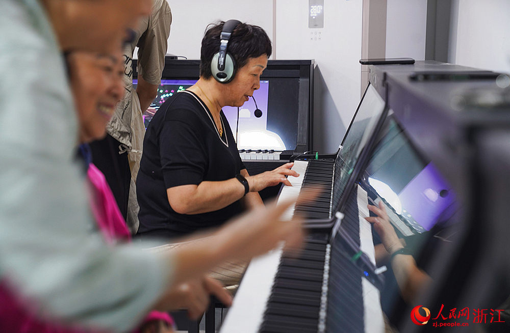 杭州翠苑街道九蓮社區居民活動室里傳出陣陣鋼琴聲，這里，一節自主鋼琴課正在火熱地進行。人民網 郭揚攝
