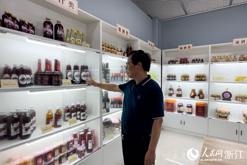 周增群介紹團隊研發的各類楊梅深加工產品。人民網記者 葉賓得攝