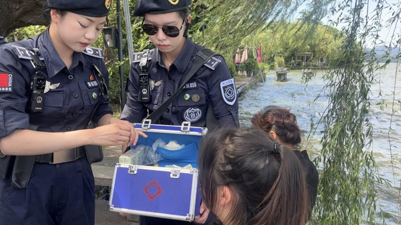 西湖女子巡邏隊隊員為游客提供消暑藥品。沈嘉寧攝