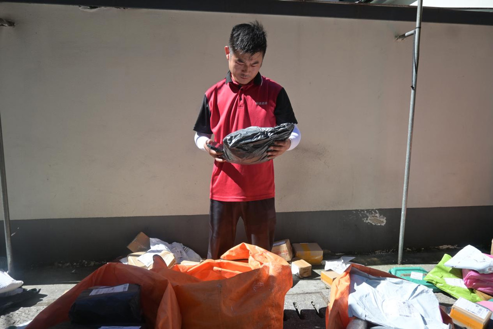 左金輪正在核對包裹信息并進行分類。劉卓爾攝