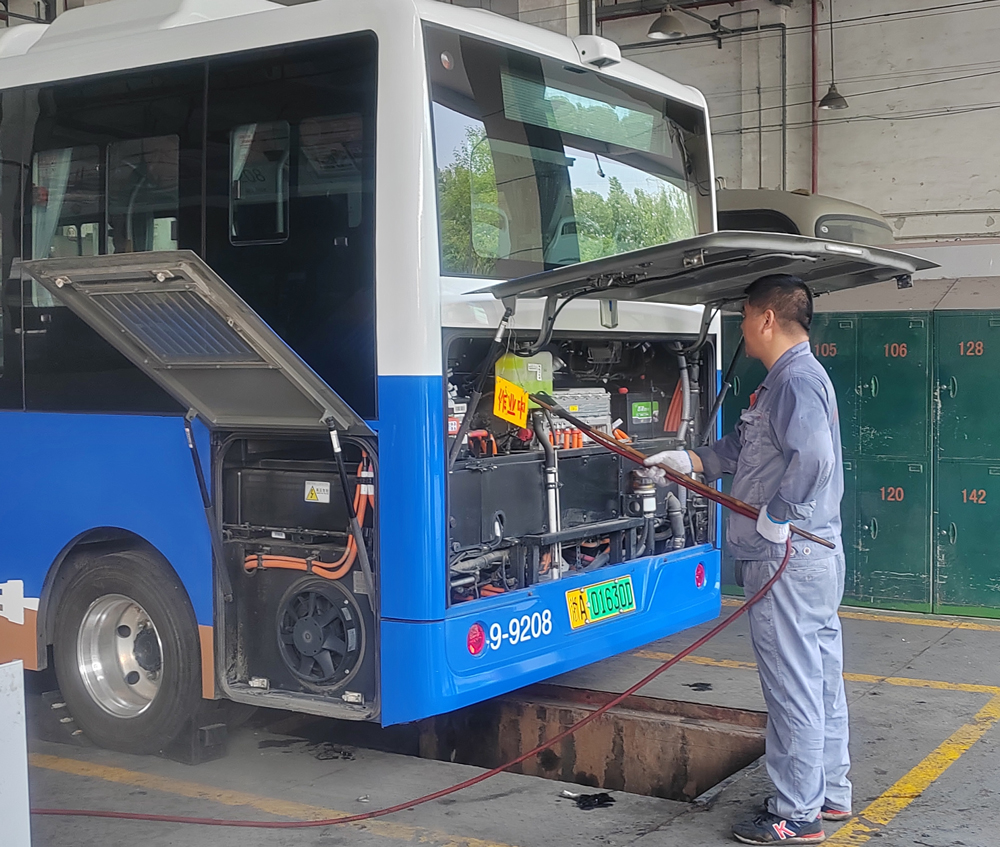 公交車維修工正在清潔電池倉。胡靜攝
