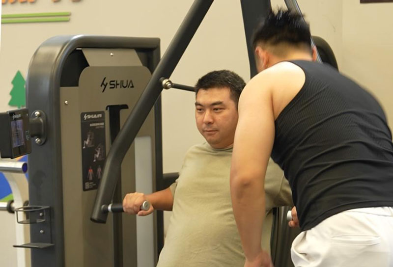 東柿社區健身房內教練張迪正在指導會員使用運動器械。吳承予攝