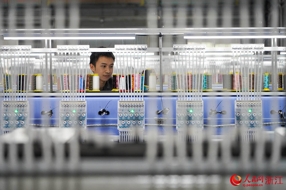 在浙江省諸暨市一家電腦刺繡機生產企業車間內，技術人員正忙著裝配、調試刺繡機。人民網 章勇濤攝