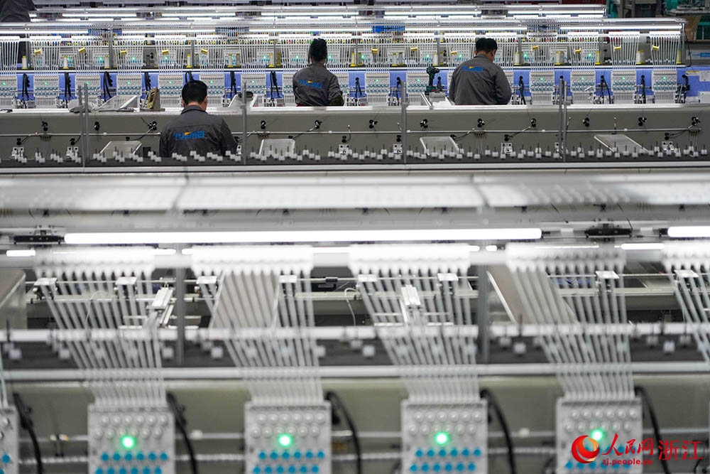 在浙江省諸暨市一家電腦刺繡機生產企業車間內，技術人員正忙著裝配、調試刺繡機。人民網 章勇濤攝
