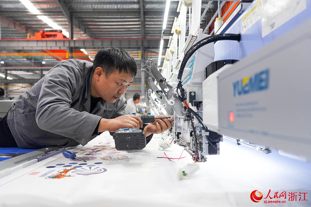 在浙江省諸暨市一家電腦刺繡機生產企業車間內，技術人員正忙著裝配、調試刺繡機。人民網 章勇濤攝