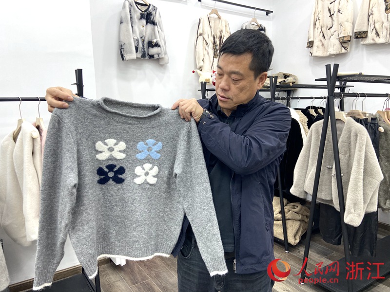 陳志建展示今年的新款毛衫。人民網 方彭依夢攝