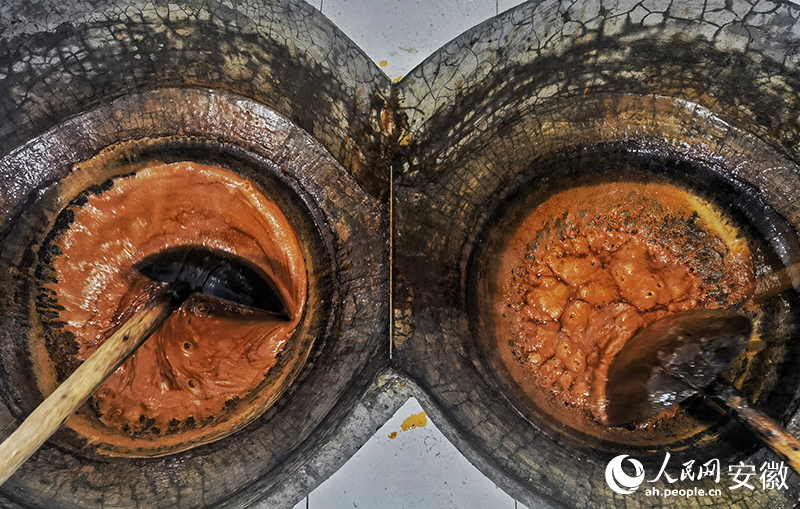 制糖師傅不斷翻炒糖漿。人民網記者 周坤攝