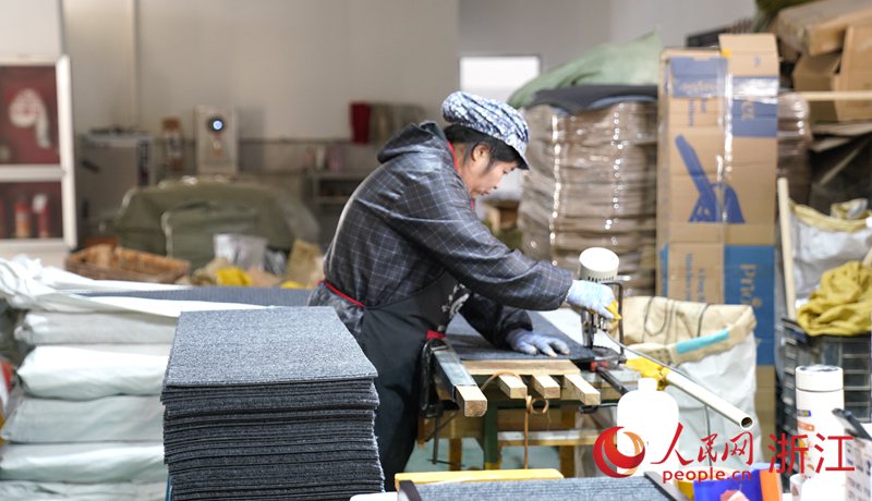 龍泉市龍康木業有限公司的新廠房內，工人們正有條不紊地生產木制寵物用品。人民網 方彭依夢攝