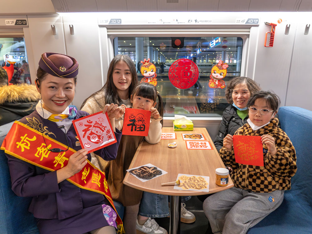 G7467次列車工作人員與旅客共同拓印福字。范晨駿攝