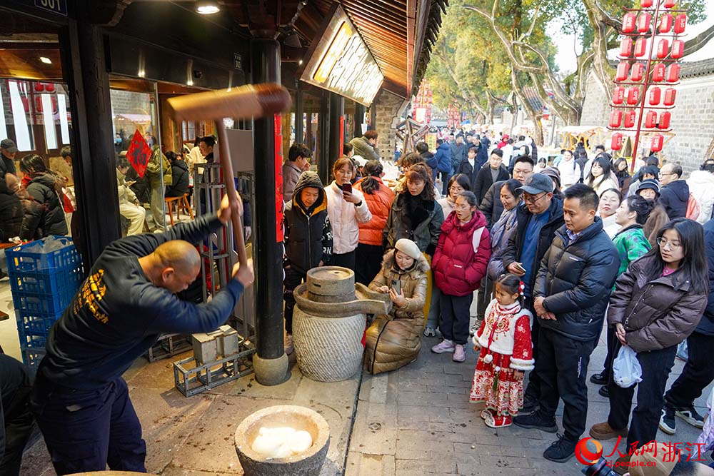 寧波市江北區慈城古縣城，市民游客觀看搗年糕。人民網 章勇濤攝