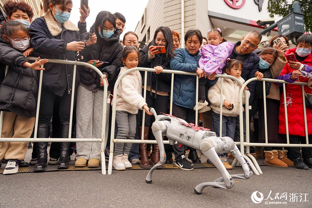 2月11日，在浙江省余姚市，機器狗正和一名小朋友互動。人民網 章勇濤攝