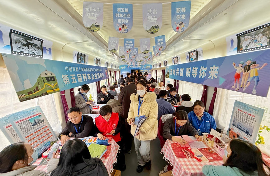 列車企業招聘會現場，各家企業在接待前來求職的旅客。周圍攝