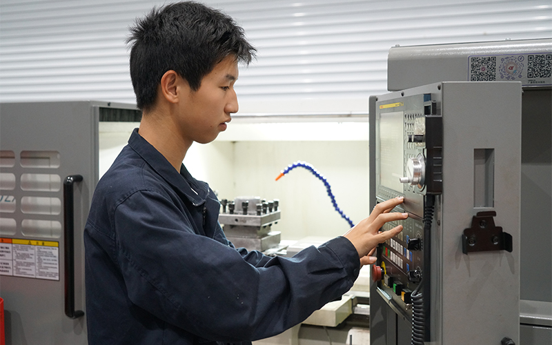 機械制造專業學生操作數控機床加工企業模具訂單。王雯靜攝