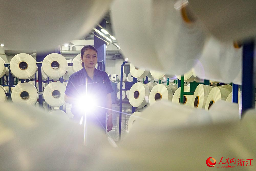 在浙江省紹興市柯橋區一家紡織企業，工人在生產線上趕制訂單。人民網 章勇濤攝