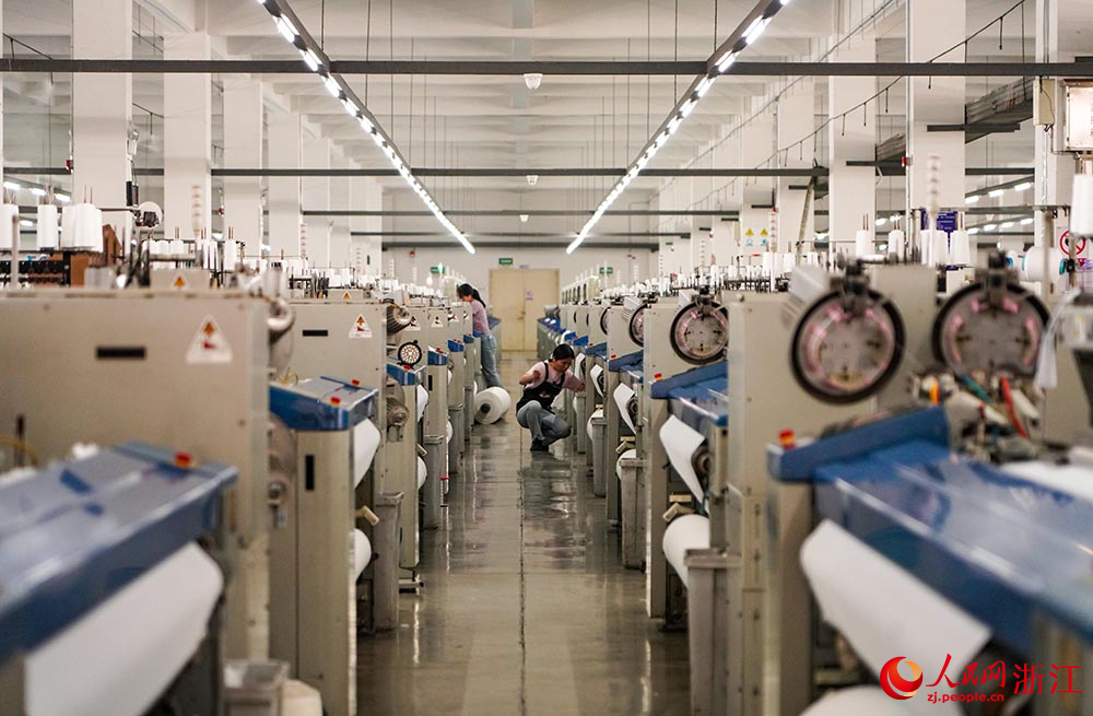 在浙江省紹興市柯橋區一家紡織企業，工人在生產線上趕制訂單。人民網 章勇濤攝