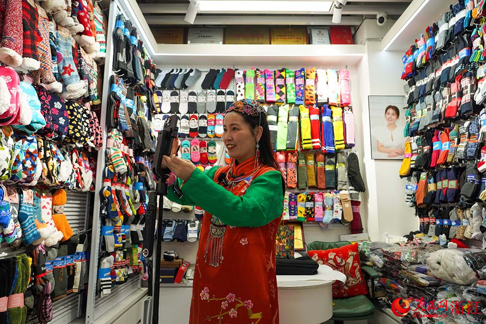 在浙江義烏國際商貿城，市場經營戶傅江燕使用人工智能小程序錄制并生成外語推介短視頻。人民網 章勇濤攝