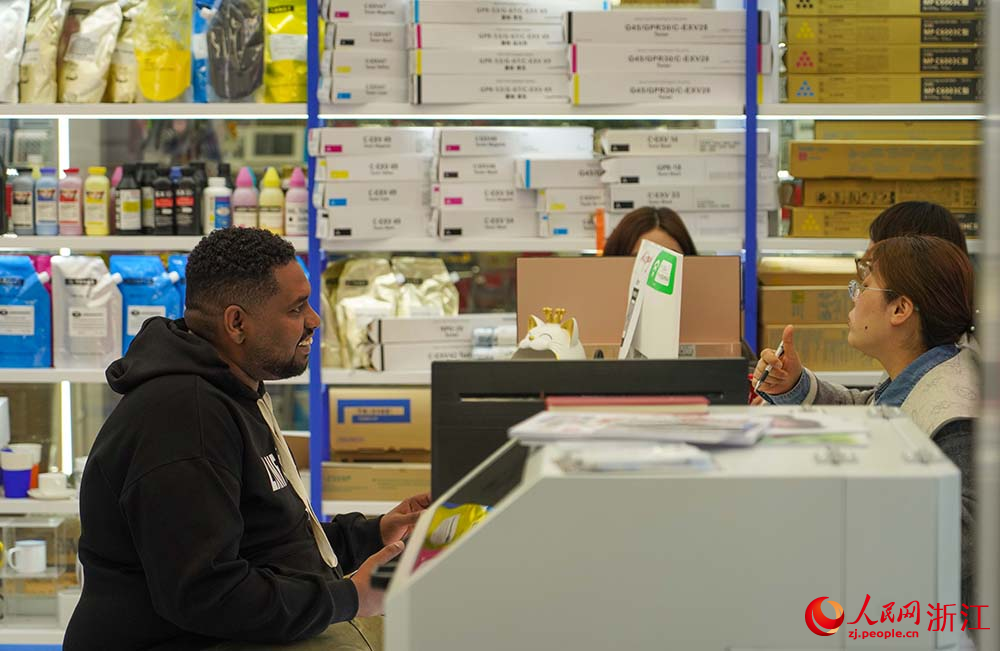 在浙江義烏國際商貿城，外商和市場經營戶在洽談生意。人民網 章勇濤攝