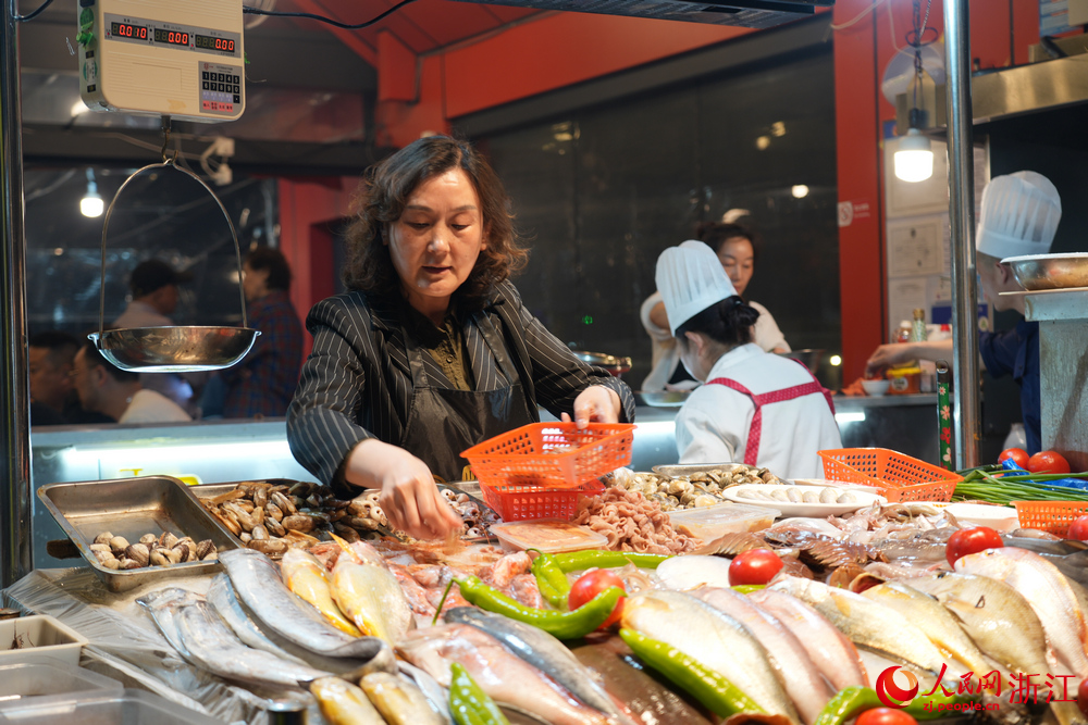 在舟山沈家門夜排檔，一位老板娘正在揀拾海鮮。人民網 陳陸洵攝