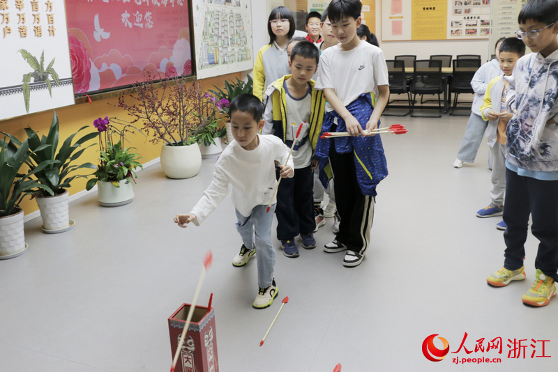 長壽橋鳳起校區春托班的孩子們走進社區玩投壺游戲。人民網記者 王麗瑋攝