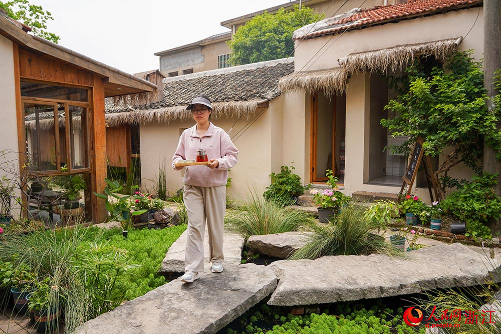 在浙江省慈溪市滸山街道大河口藝術部落，茶藝師在給客人送茶。人民網 章勇濤攝