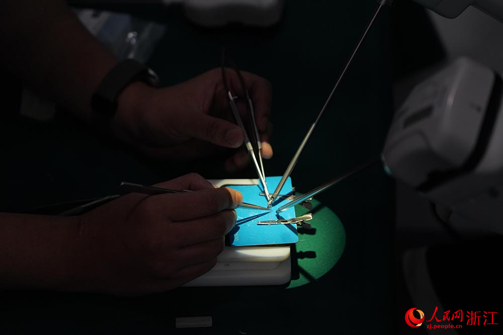 5月27日，研發人員使用顯微外科手術機器人進行仿真血管的吻合操作。人民網 章勇濤攝