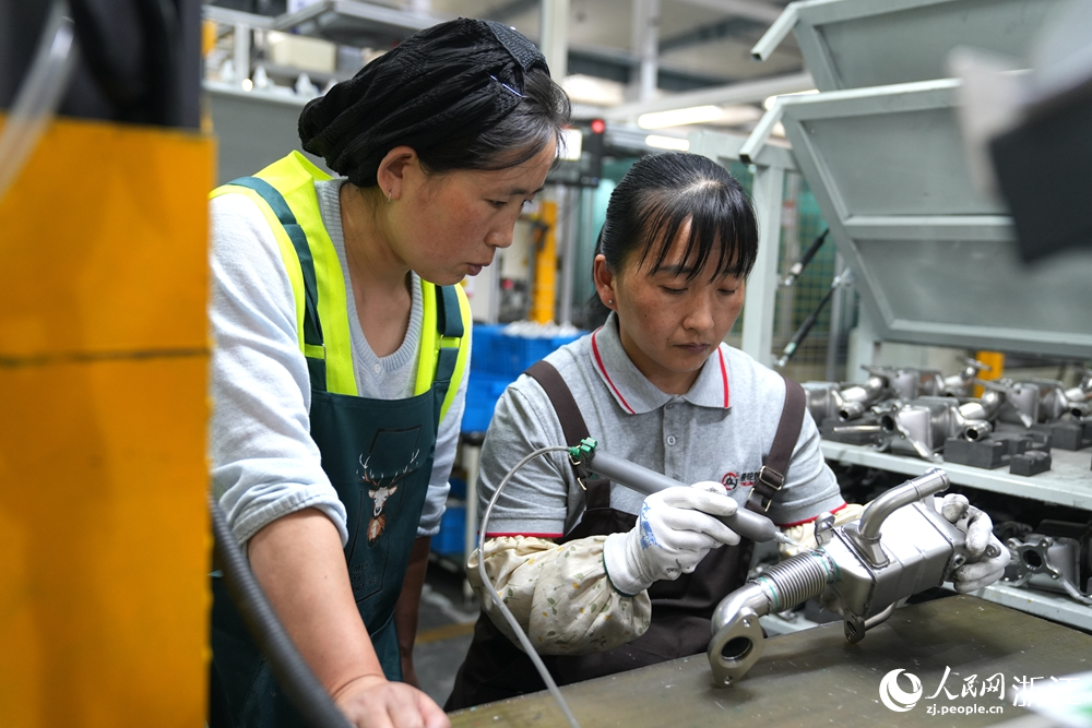 浙江銀輪機械股份有限公司生產車間內，工人正在研究如何處理零件。人民網 陳陸洵攝