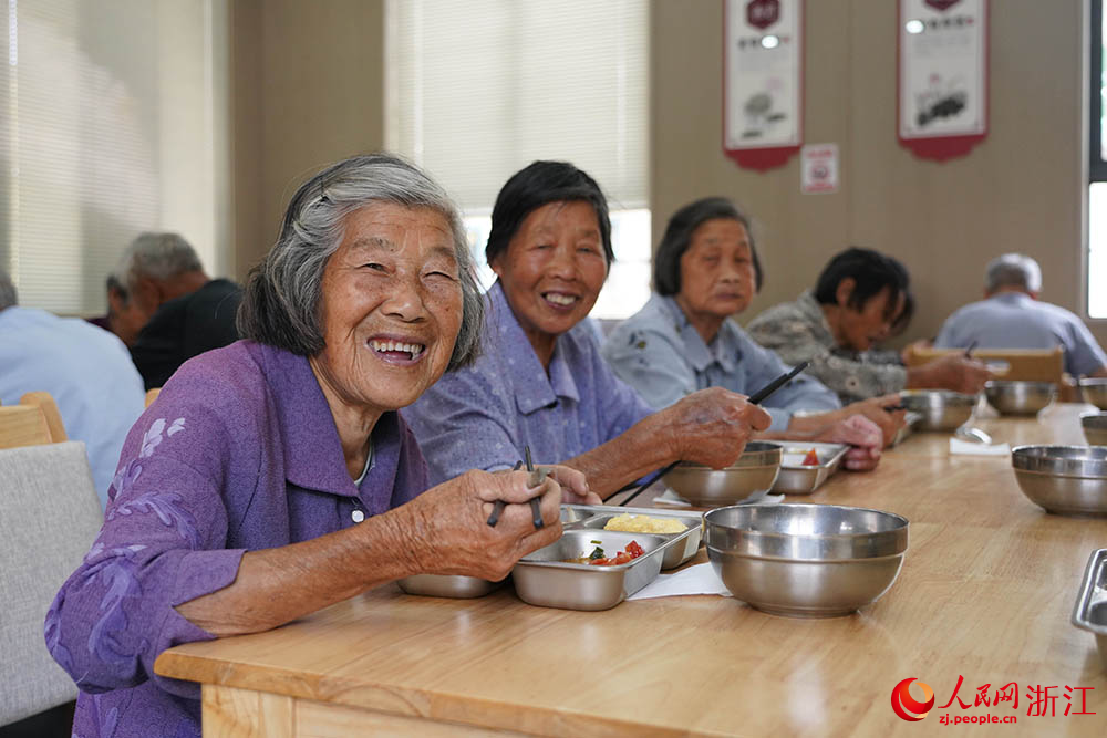 在浙江省紹興市柯橋區王壇鎮老年食堂里，飯菜飄香，老人們圍坐桌前，邊吃邊聊，其樂融融。人民網 章勇濤攝