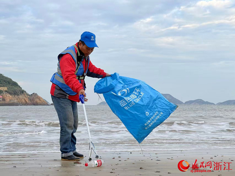 “小藍之家”的工作人員在海灘撿拾塑料垃圾。人民網記者 郭揚攝